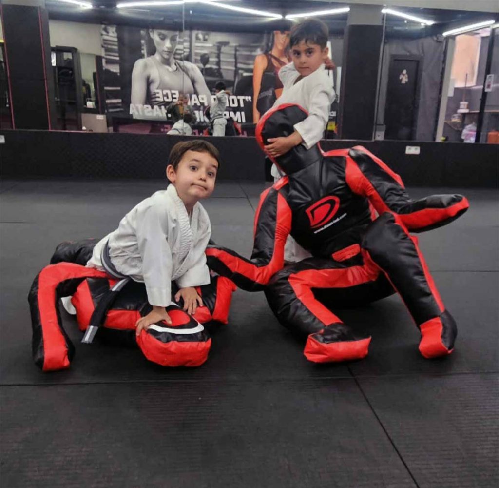 ninos kimono blanco entrenan jiu jitsu grappling dummy